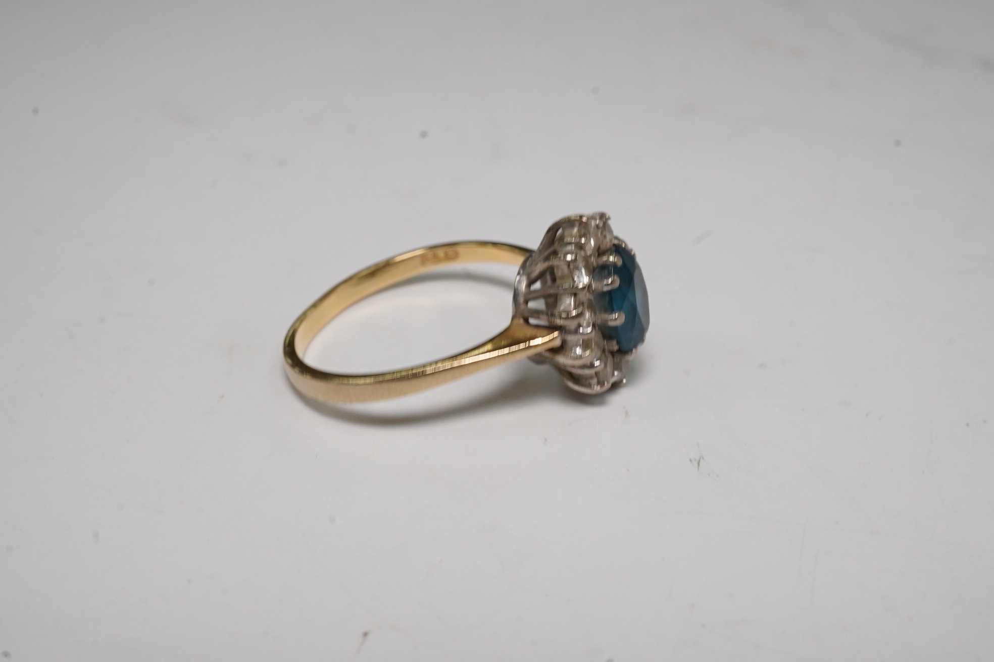 A modern 18ct gold, blue topaz and diamond set oval cluster ring, size M, gross weight 3.5 grams. Condition - fair